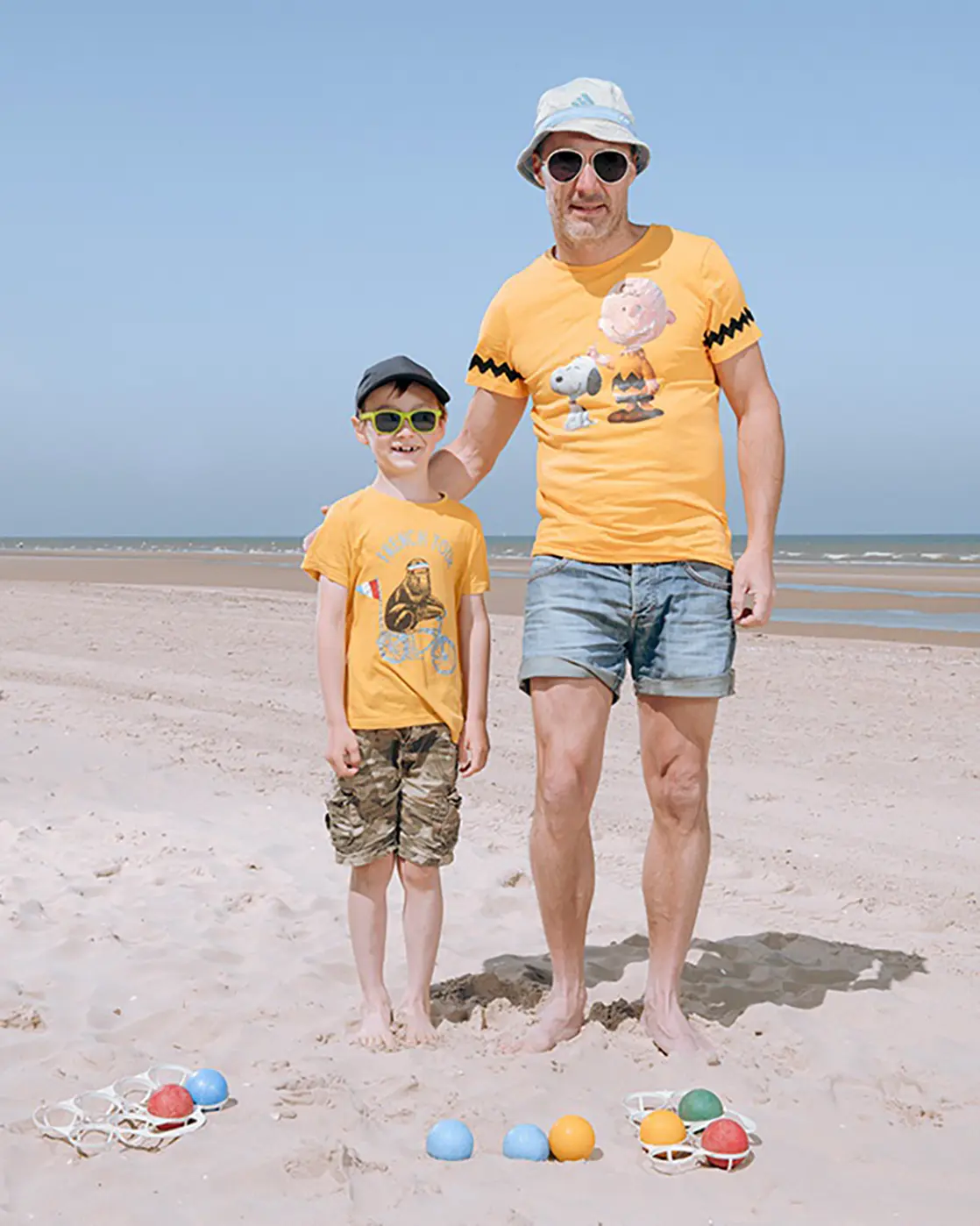 Père et fils sur la plage qui joue à la pétanque