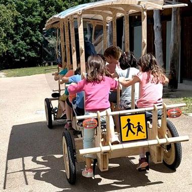 Photo illustrant le Woodybus, pesant seulement 200 kg, permet à 8 enfants accompagnés d’un adulte de se rendre à l’école en pédalant, à l’aide d’une assistance électrique. 