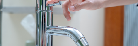 Personne fermant un robinet