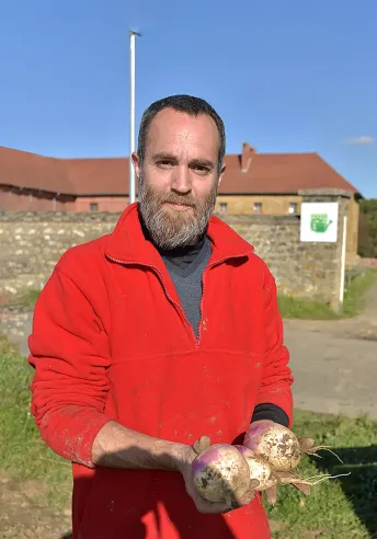 Un homme tient des oignons