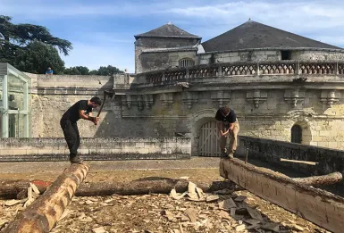 deux charpentier entrain de couper des tronc d'arbre