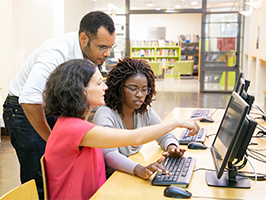 Trois personnes regardent un écran d'ordinateur