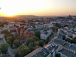 photographie d'une ville moyenne prise du ciel avec le couché de soleil en fond