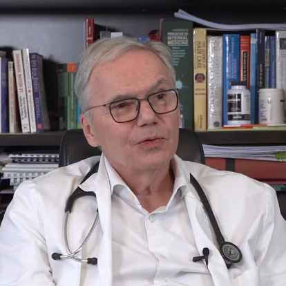 Portrait du Dr Christophe de Jaeger à son bureau, un stéthoscope autour du cou.